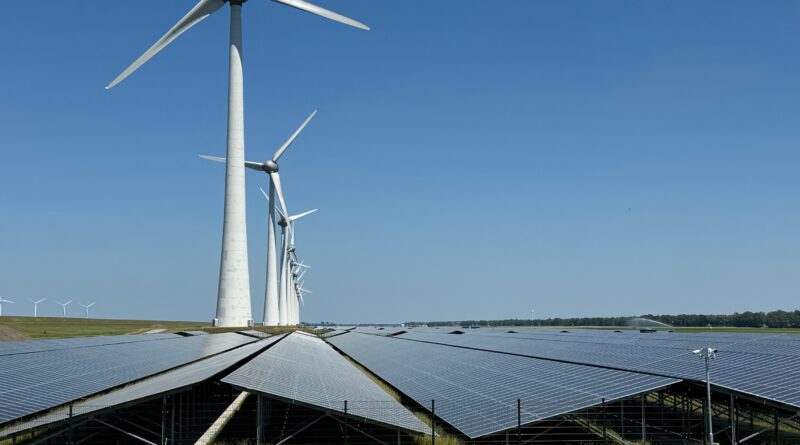 Onshore 7.5 MW wind turbines and solar at 5 meters below sea level with offshore turbines visible to left, photo by author